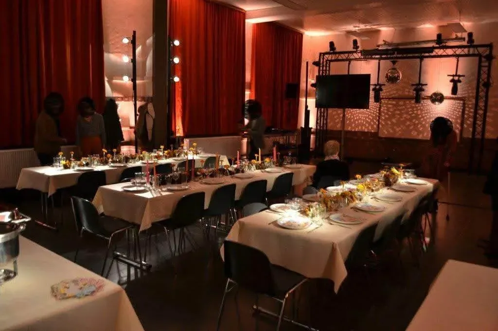 Photo intérieure de la salle de la butte lors d'une soirée. Tables dressées.